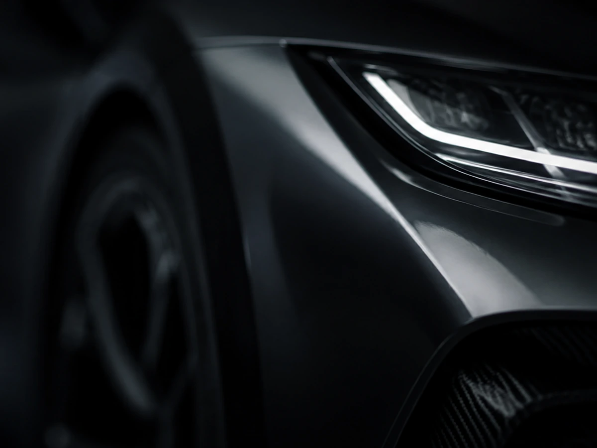 Premium vehicle headlight and body detail in a dark studio